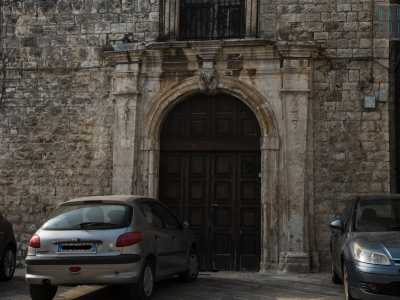 Un grande portone di legno, inserito in un arco in pietra, sbarra per� l�ingresso, chiuso da tanto tempo